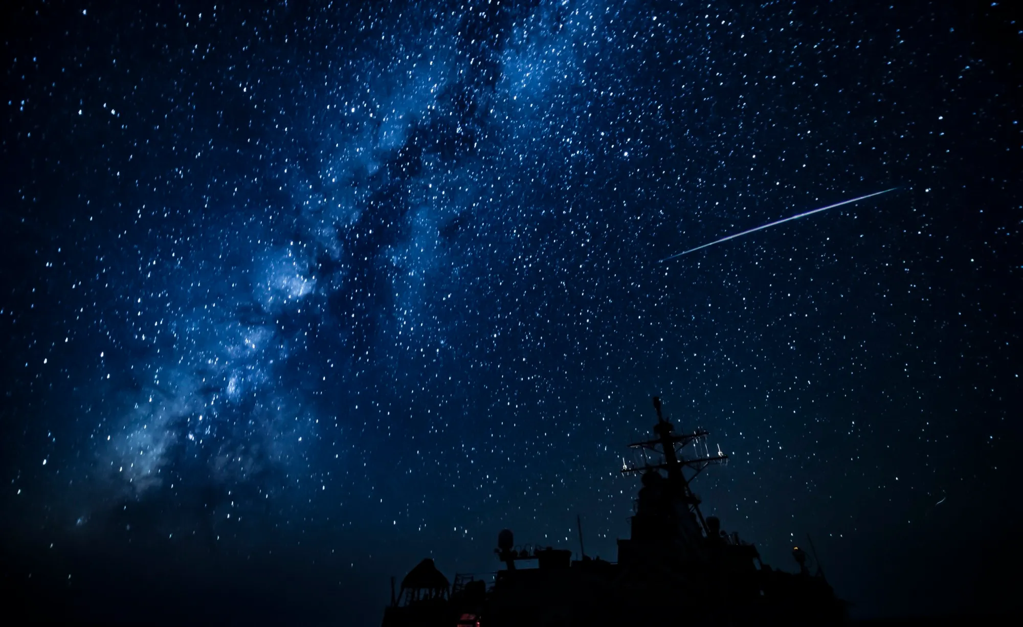 The Milky Way and a meteor over a destroyer's superstructure